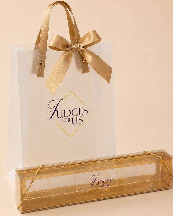 Caixa dourada retangular da Fudges For Us com sacola