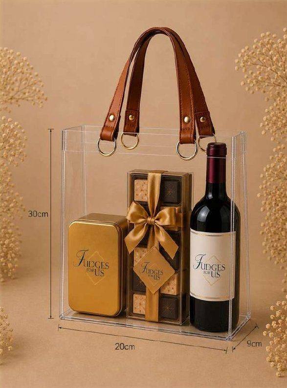 Sacola com lata de fudges, caixa com laço e garrafa de vinho