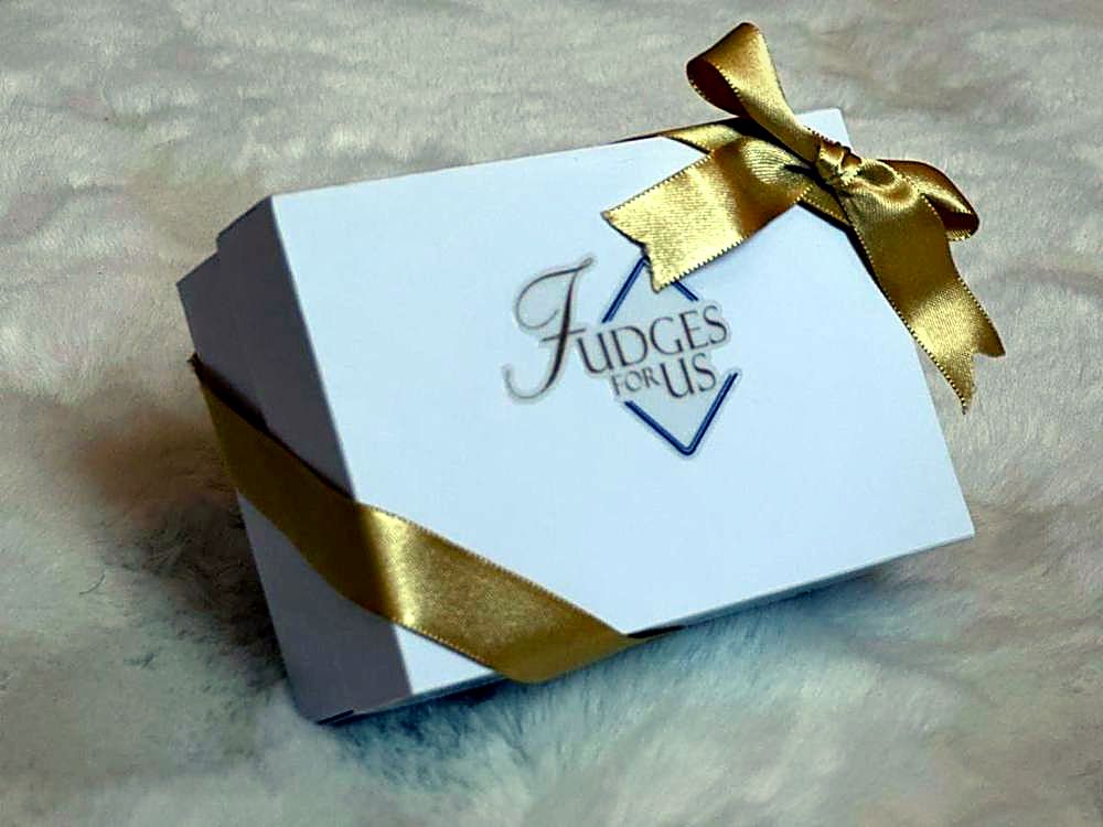 Caixa branca da Fudges For Us com laço dourado